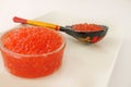 Red caviar in a bowl with wooden spoon over white background Royalty Free Stock Photo