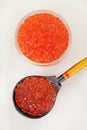 Red caviar in a bowl with wooden spoon over white background Royalty Free Stock Photo