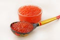 Red caviar in a bowl with wooden spoon over white background Royalty Free Stock Photo