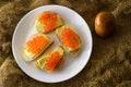 Red caviar on bread and butter closeup, four sandwiches on white plate. View from above Royalty Free Stock Photo