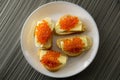 Red caviar on bread and butter closeup, four sandwiches on white plate. View from above Royalty Free Stock Photo