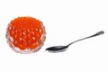 red caviar in a glass caviar bowl with a spoon lying next to it on a white isolated background Royalty Free Stock Photo