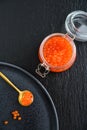 Red caviar in the glass jar on black slate background Royalty Free Stock Photo