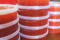 Red caviar plactic jars, rows of salted canned red caviar containers filled to the top on a seafood production, packaging and