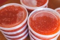 Red caviar plactic jars, rows of salted canned red caviar containers filled to the top on a seafood production, packaging and