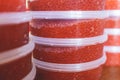 Red caviar plactic jars, rows of salted canned red caviar containers filled to the top on a seafood production, packaging and