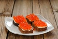 Red caviar on rye bread and butter on white plate