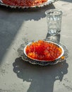 Red caviar on silver plate with vodka shot on gray Royalty Free Stock Photo