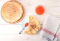 Red caviar in the spoon and pancakes in plate