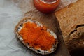 Red caviar toasts sandwich with silver knife, bowl of tasty red caviar with spoon and fresh baked homemade healthy bread Royalty Free Stock Photo