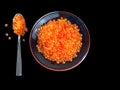 Red caviar in a transparent plate. Salmon ROE on a spoon. Delicacy on a black background. Seafood