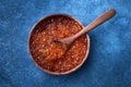 Red caviar in a wooden bowl and spoon with caviar on blue background. Top view, copy space Royalty Free Stock Photo