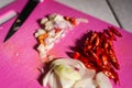 red Cayenne pepper, shallot, onion and garlic on pink cutting board. cooking raw food