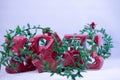 A red ceramic love letters ornament with tinsels displayed on a white background