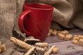 Red ceramic mug with tea, cookie sticks with chocolate and white icing, and pieces of brown cane sugar on a wooden background. Royalty Free Stock Photo