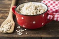 The red ceramic saucepan with white polka dots complete crumbly barley porridge Royalty Free Stock Photo