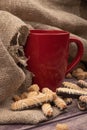 A red ceramic tea mug, cookie sticks with chocolate and white icing, and pieces of brown cane sugar on a wooden background. Close Royalty Free Stock Photo