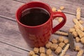 A red ceramic tea mug, cookie sticks with chocolate and white icing, and pieces of brown cane sugar on a wooden Royalty Free Stock Photo