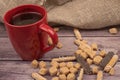 A red ceramic tea mug, cookie sticks with white icing and chocolate , and pieces of brown cane sugar on a wooden background. Close Royalty Free Stock Photo