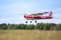 Red Cessna 150 plane is coming in to landing