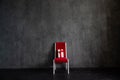 One red chair with a gift in the interior of a dark room Royalty Free Stock Photo