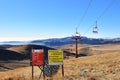Red chair ski lift and indicator board in Bucegi mountains, Romania