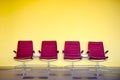 Red chairs against yellow wall.