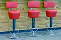 Red chairs in a bar near a wooden rack Royalty Free Stock Photo