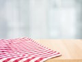 Red checked tablecloth on wood with blur home window background