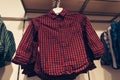 Children`s red checkered shirt on trempel in the children`s clothing store in shopping mall