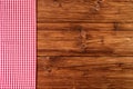 Red checkered tablecloth on old wooden background Top view, text space