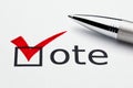 Red checkmark on vote checkbox, pen on ballot