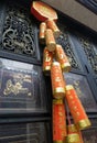 Red cheery Chinese New Year Firecrackers hanging as decorations on shrine wooden door