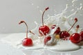 Red cherries meet milk splash on crisp white backdrop