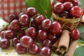 Red cherries with stems and cinnamon rods in front of litlle basket Royalty Free Stock Photo