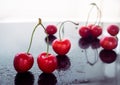 Red cherries are reflected against a black mirror background Royalty Free Stock Photo