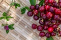 Red cherries on a wooden surface. Juicy cherries and a clover in the orchard in a summer sunny day. Sweet fruits. Top view Royalty Free Stock Photo