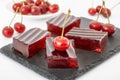 Red cherry jelly dessert with gelatin. Fruit jell squares on black board