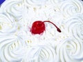 Red cherry from marmalade on white creamy flowers of a biscuit cake Royalty Free Stock Photo