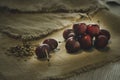 red cherry pile in and ground almonds for sprinkling sweet food on the hemp sack sheet above a wooden table Royalty Free Stock Photo