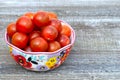 Red cherry tomatoes in a bowl with floral pattern