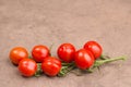 Red cherry tomatoes on a brown textured background, empty copy space