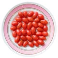 Red cherry tomatoes on plate with water drops.