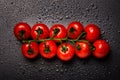 Red cherry tomatoes on a vine isolated on a black wet background Royalty Free Stock Photo