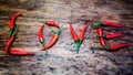 Red chili as letters for love on rustic wooden table