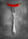 Red chili on a fork with a smooth black and white background