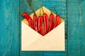 Red chili pepper in a blue envelope on old wooden background Royalty Free Stock Photo