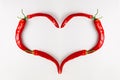 Red chili pepper heart on white wood background. Love hot spicy mexican food, valentine day concept. Flat lay, top view Royalty Free Stock Photo