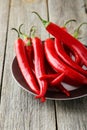Red chili pepper on plate on the grey wooden background Royalty Free Stock Photo