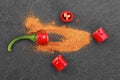 Red chili pepper slices and powder on black stone table Royalty Free Stock Photo